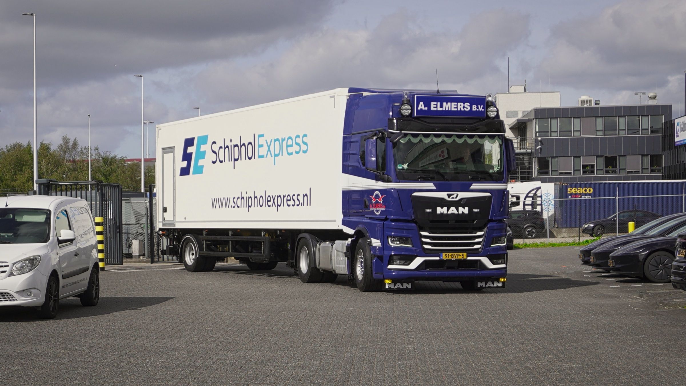 Vrachtwagen met Schiphol Express-trailer rijdt het terrein af