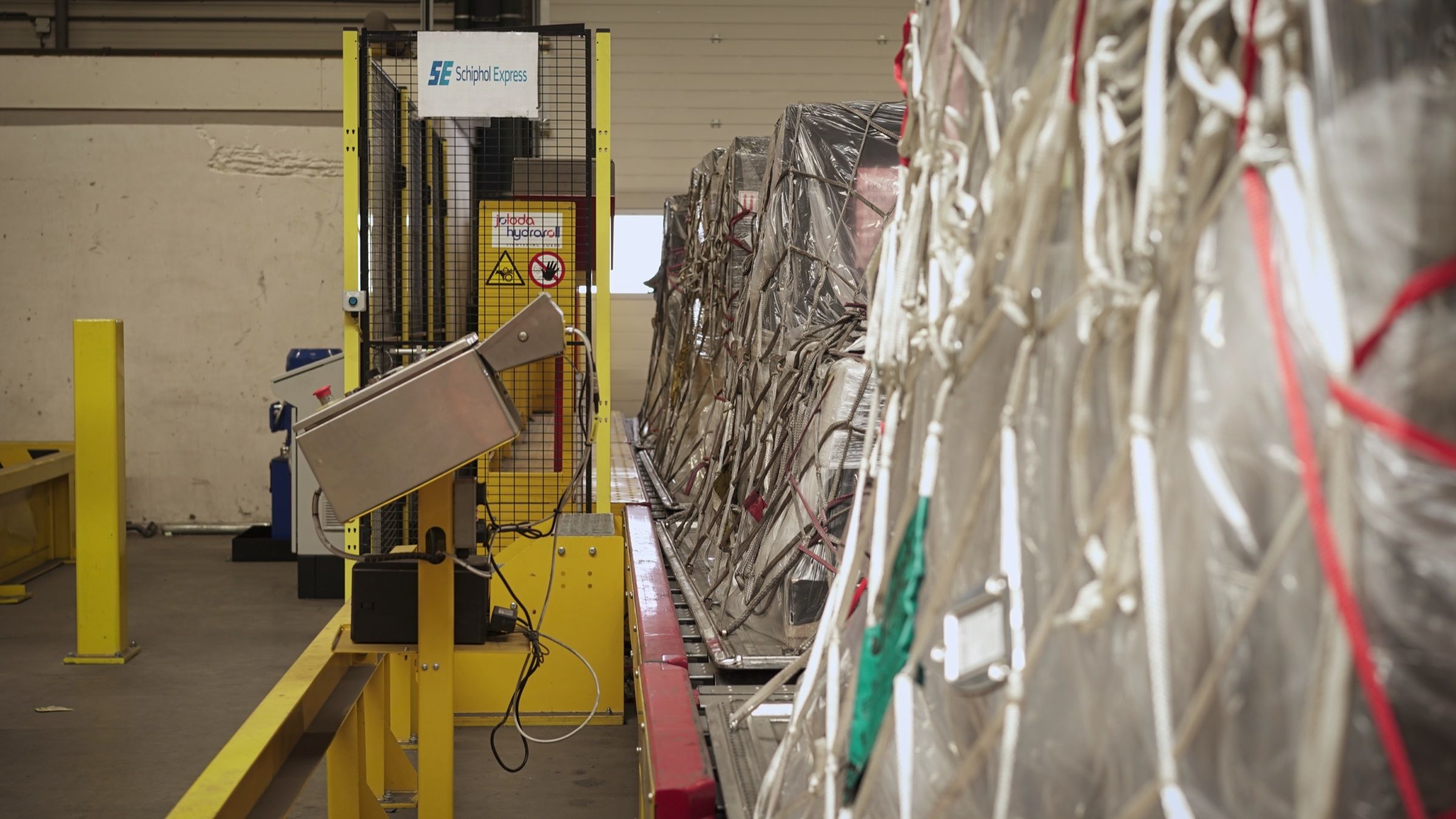 Luchtvrachtpallets onder netten op de rollerbaan in ons warehouse